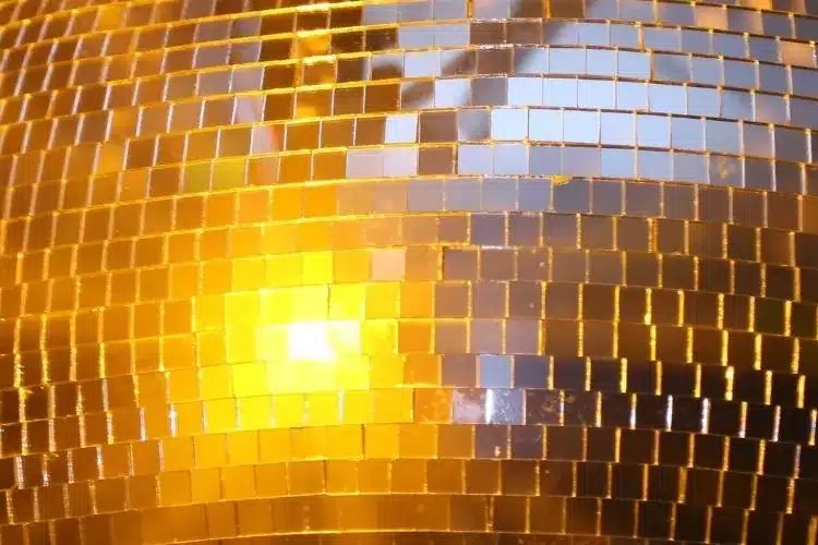 Close-up of mirror ball tiles reflecting warm gold light