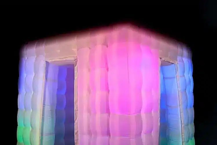 Inflatable photo booth enclosure lit from inside in a dark room