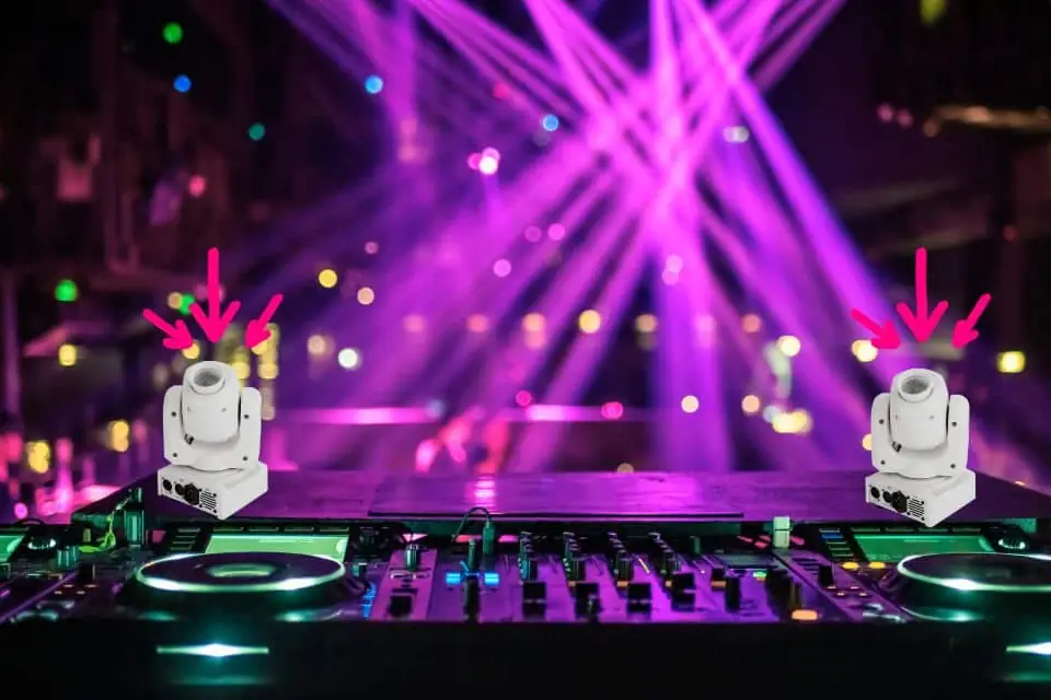 Two white moving spotlights on a DJ console with pink and purple light beams behind them