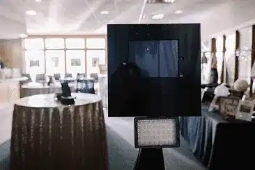 Photo booth screen on a stand with a light panel in an event room