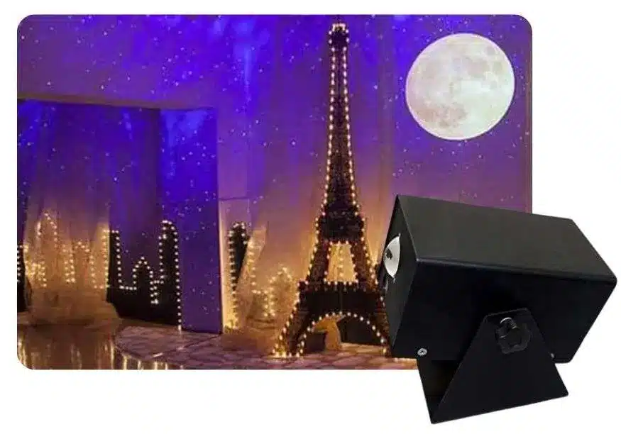 Room lit with projected stars and a glowing moon beside a starry night projector